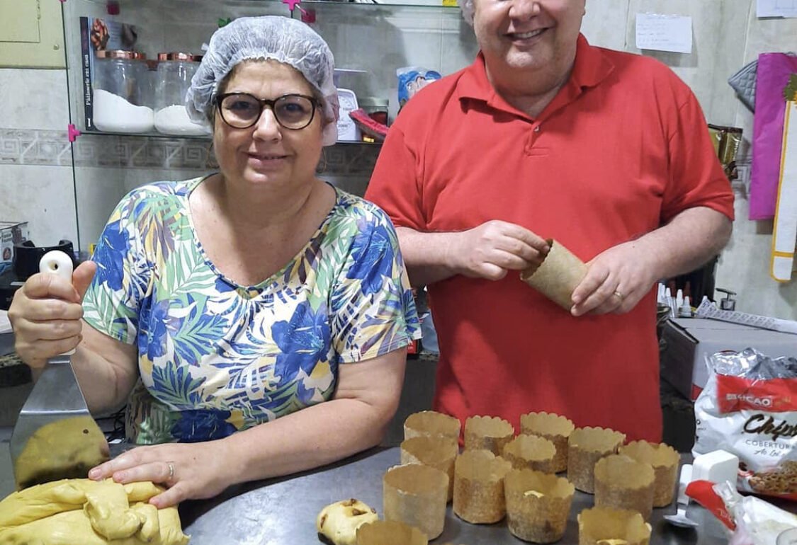 Garotinho põe a mão na massa para fabricar panetones