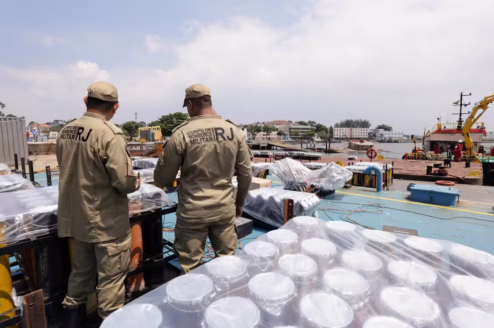 O Corpo de Bombeiros Militar do Estado do Rio de Janeiro (CBMERJ) concluiu nesta terça-feira (30) a vistoria das balsas que serão usadas na tradicional queima de fogos do réveillon de Copacabana. As 19 embarcações foram aprovadas após análise da Diretoria-Geral de Diversões Públicas (DGDP). A inspeção ocorreu na Praia da Ribeira, na Ilha do Governador, na Zona Norte do Rio. No local, os militares avaliaram uma série de critérios técnicos e de segurança exigidos para eventos de grande porte. Entre os pontos analisados estiveram a estabilidade das balsas, o posicionamento dos artefatos pirotécnicos, os sistemas de acionamento, o distanciamento da orla e o cumprimento integral das normas de segurança previstas em projeto. Avaliação técnica e operação remota De acordo com o porta-voz do CBMERJ, tenente-coronel Fábio Contreiras, a vistoria seguiu rigorosamente o projeto apresentado na fase documental. Foram analisados o layout das estruturas, a quantidade, o tipo e o tamanho dos artefatos pirotécnicos. O oficial destacou ainda que, durante o espetáculo, não haverá equipes, brigadistas ou operadores a bordo das balsas. Toda a operação será realizada de forma remota, conforme o planejamento técnico aprovado. Para situações de emergência, a prevenção e a resposta a incêndios estarão garantidas por um rebocador de apoio, equipado com bomba de incêndio e posicionado estrategicamente para atuação imediata, se necessário. Estrutura com ART e apoio de outros órgãos A montagem da estrutura dos fogos conta com Anotação de Responsabilidade Técnica (ART), emitida por engenheiro legalmente habilitado. Segundo os bombeiros, isso assegura que toda a instalação segue os critérios técnicos e de segurança exigidos. A ação de vistoria contou ainda com a participação da Capitania dos Portos, da Divisão de Fiscalização de Armas e Explosivos (DFAE) da Polícia Civil e da Riotur. Neste réveillon, as 19 balsas serão distribuídas ao longo da orla de Copacabana. O número de artefatos pirotécnicos será quase o dobro do utilizado na virada de 2024, e o espetáculo terá duração aproximada de 12 minutos. Alerta para mar agitado e esquema especial de segurança O tenente-coronel Fábio Contreiras também fez um alerta ao público que pretende acompanhar a festa próximo ao mar. Segundo ele, as condições marítimas no dia 31 não serão favoráveis para banho. A previsão indica ondas entre 2 e 2,5 metros, com mar agitado, valas e correntes de retorno. O Corpo de Bombeiros reforça que não é seguro mergulhar e que drones serão usados para emitir avisos sonoros ao público ao longo da orla. Para a operação de Réveillon, o CBMERJ vai empregar cerca de 1.500 militares, com apoio de 360 viaturas, 250 embarcações, três aeronaves e 13 drones, incluindo dois mega drones equipados com megafone e farol de longo alcance. A corporação contará ainda com três Postos de Comando e Controle e 38 novos postos móveis de salvamento marítimo. Em Copacabana, principal ponto de concentração de público, serão mobilizados 170 bombeiros, seis forças-tarefa, 20 postos de guarda-vidas e equipes médicas em motos aquáticas para atendimento rápido a possíveis ocorrências.