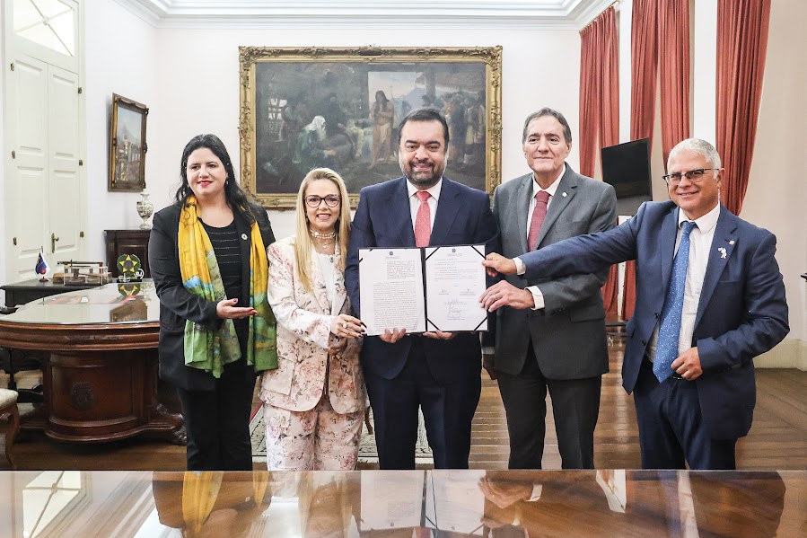 Governador Claudio Castro, ao centro, na assinatura do termo com representantes tes da OPAS. Divulgação: Governo do Estado